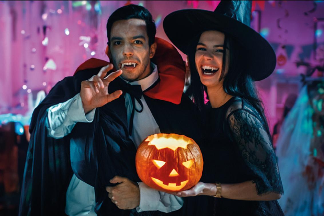 Deux amis déguisés en vampire et en sorcière pour fêter Halloween.