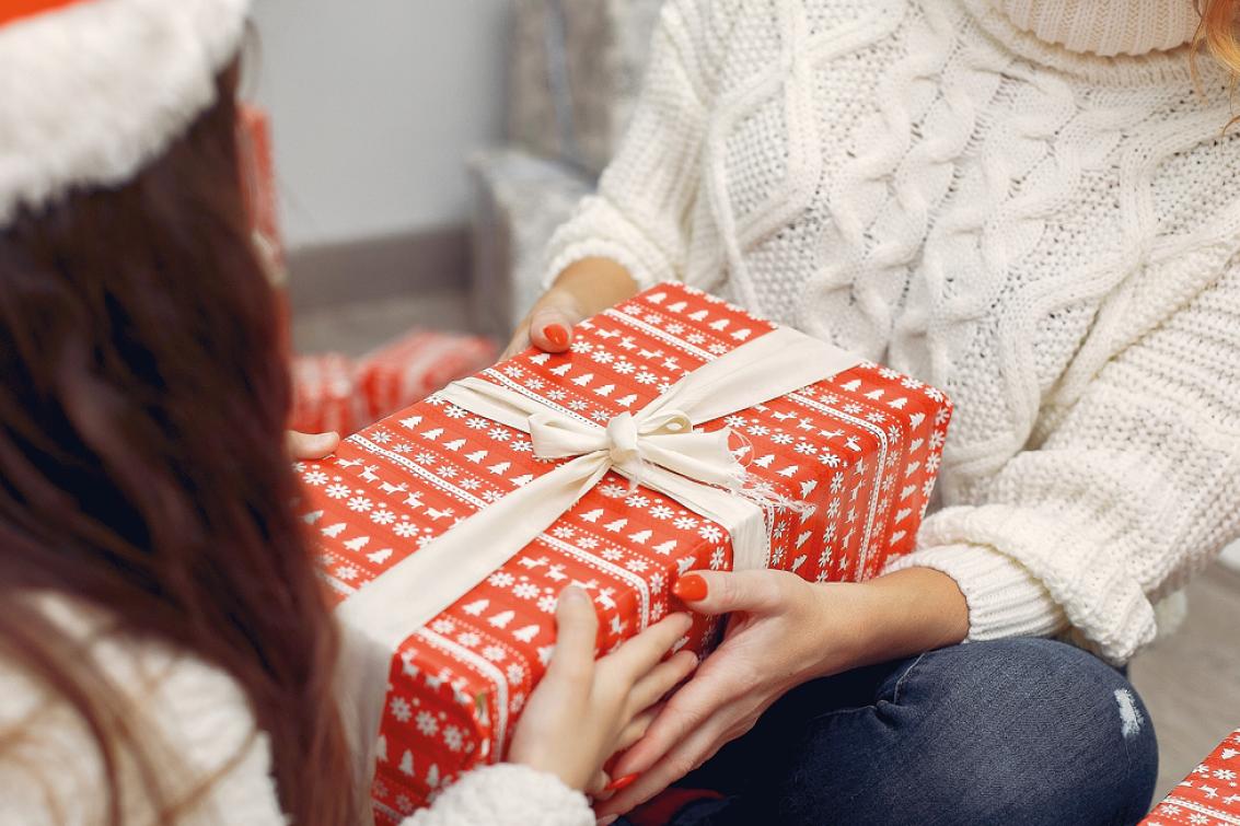 photographie d'une jeune fille recevant un cadeau de Noël de sa mère