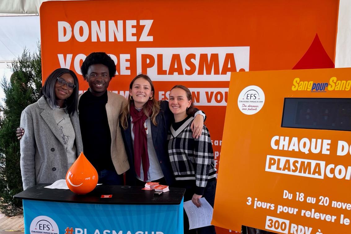 Les participants au discours devant un stand dédié au don de plasma