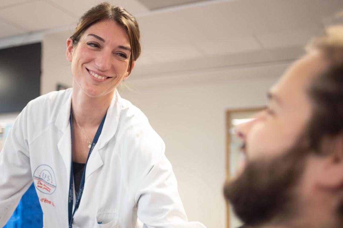 Une infirmière de l'EFS sourit à un donneur