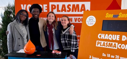 Les participants au discours devant un stand dédié au don de plasma